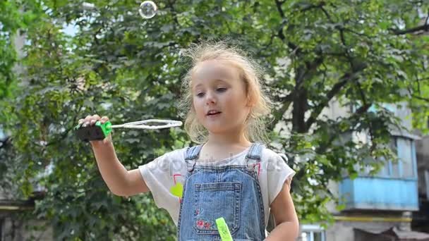 Klein meisje blazen zeepbellen — Stockvideo