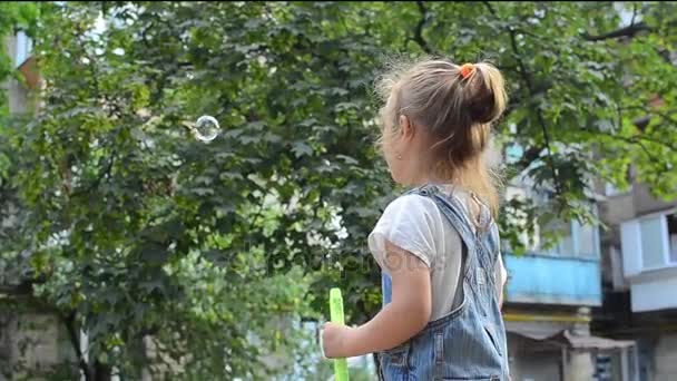 Kleines Mädchen pustet Seifenblasen — Stockvideo