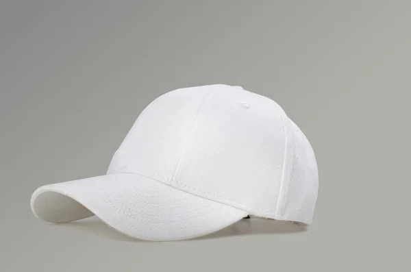 회색 배경에 흰색 야구 모자 스톡 이미지