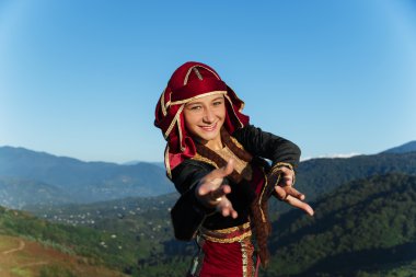 genç kadın Gürcü Ulusal giysileri dağlar açık havada yaz güneşli dans