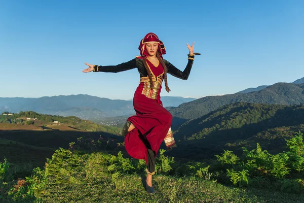 Giovane donna che balla georgiano vestiti nazionali montagne all'aperto estate soleggiato — Foto Stock