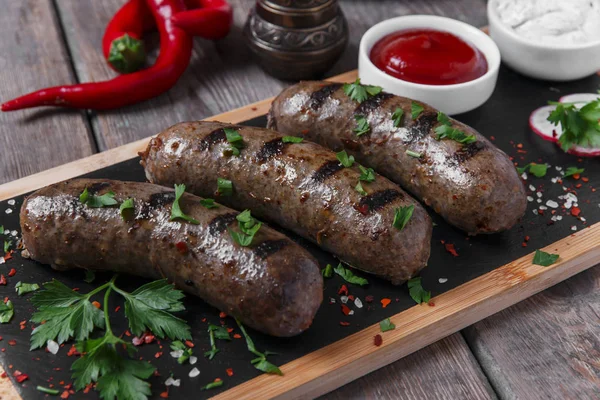 Salsichas cozidas caseiras fritas em uma carne grelhada — Fotografia de Stock