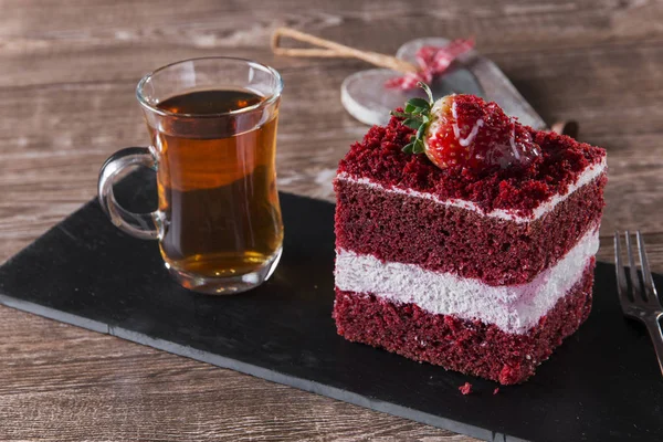 Del av röd sammet tårta med vit glasyr är garnerad med jordgubbar närbild — Stockfoto