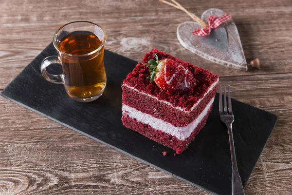 Шматочок червоного оксамитового торта з білим морозивом прикрашений полуницею крупним планом — стокове фото