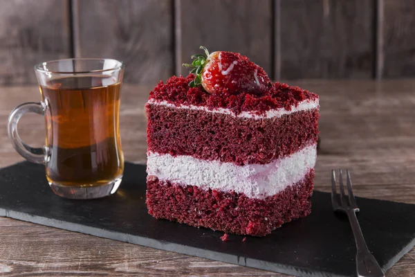 Rebanada de pastel de terciopelo rojo con glaseado blanco se adorna con fresas de cerca —  Fotos de Stock