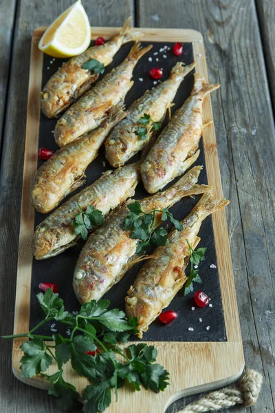 Fried fish goatfish surmullet with lemon on board — Stock Photo, Image