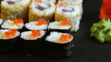 suşi bölümünü alarak yemek çubukları ile kırmızı havyar rulo