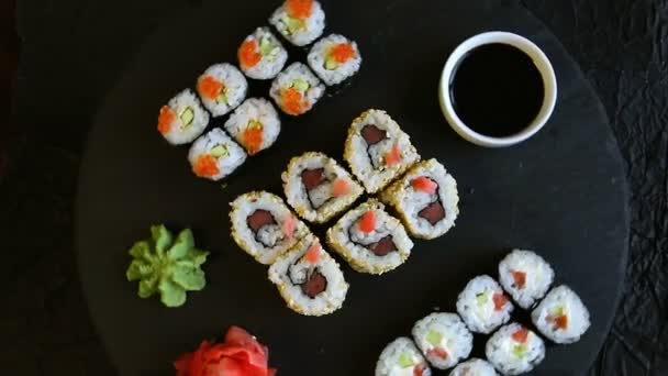 Sushi eten geserveerd op zwarte stenen wasabi gember — Stockvideo