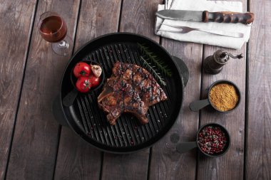 Masanın üzerine sebzeli ızgara üzerinde kemik biftek