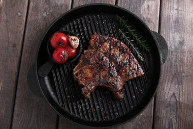 Masanın üzerine sebzeli ızgara üzerinde kemik biftek