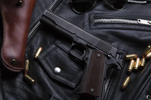 Pistola Colt con balas y funda se apoya en una chaqueta de cuero — Foto de Stock