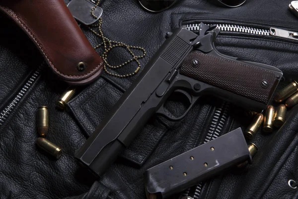 Pistola Colt con balas y funda se apoya en una chaqueta de cuero — Foto de Stock