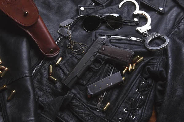 Pistola Colt con balas y funda se apoya en una chaqueta de cuero — Foto de Stock