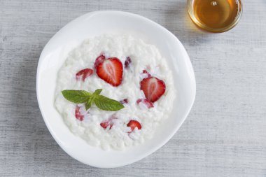 Süt pirinç lapası bir tabak içinde çilek ile