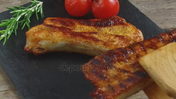 Las costillas de cerdo fritas ponen en una tabla de porciones cámara lenta — Vídeos de Stock