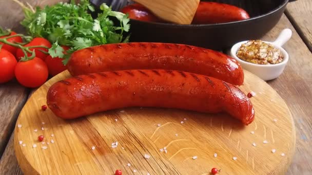 Grilled sausages are laid out on a wooden board slow motion footage — Stock Video