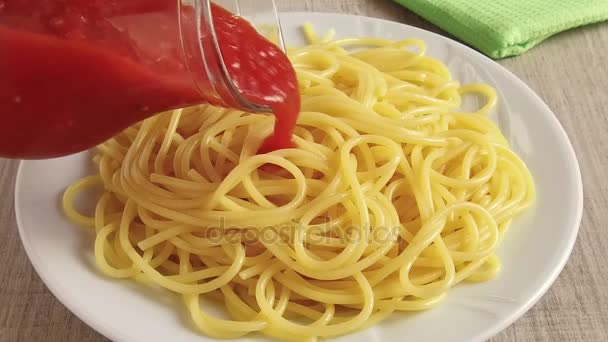 Pasta de espaguetis en un plato vertido salsa de tomate imágenes en cámara lenta — Vídeo de stock