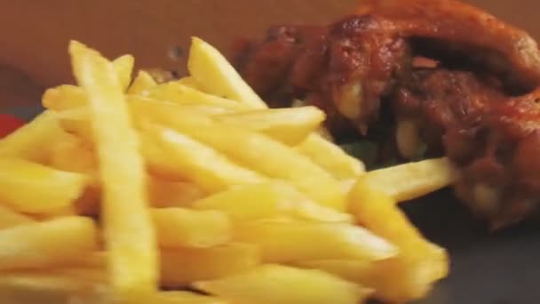 Fried chicken wings french fries sauce on a stone plate turns — Stock Video