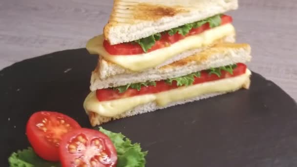 Жареные тосты с сыром и помидорами на каменной поверхности вращаются — стоковое видео