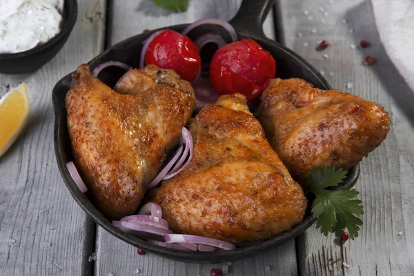 Жареные куриные крылышки с соусом в сковороде — стоковое фото