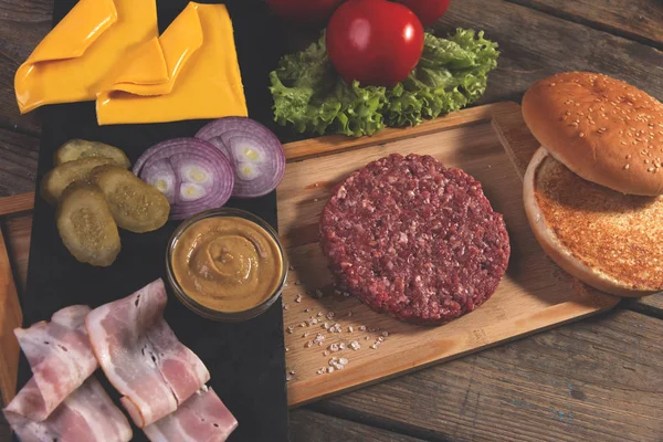 Házi hamburger friss zsemle, sós uborka, marhahús pogácsa, bacon — Stock Fotó