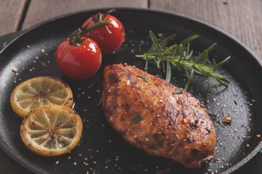 bir tava üzerinde limon domates biberiye ile kavrulmuş tavuk fileto meme