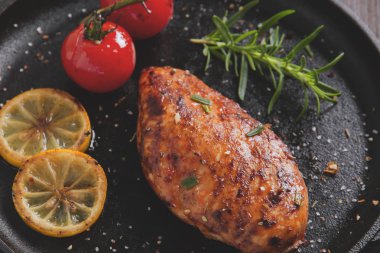 bir tava üzerinde limon domates biberiye ile kavrulmuş tavuk fileto meme