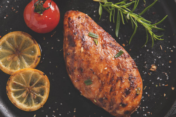 roasted chicken fillet breast with lemon tomato rosemary on a frying pan