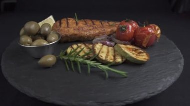 Sebzeli ızgara tavuk filetosu. Siyah arka plan rotasyonu 360 derece. 4k