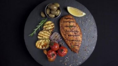 Sebzeli ızgara tavuk filetosu. Siyah arka plan rotasyonu 360 derece. 4k