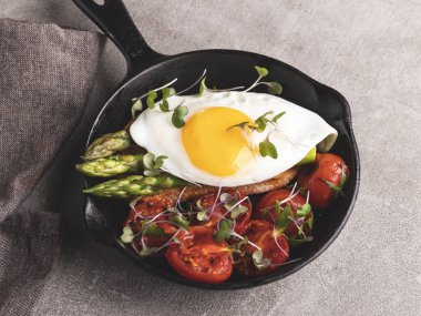 Kızarmış yumurtalı tost, kızarmış domatesli kuşkonmaz kahvaltısı, sağlıklı yemek.