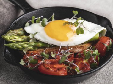 Kızarmış yumurtalı tost, kızarmış domatesli kuşkonmaz kahvaltısı, sağlıklı yemek, yakın çekim.