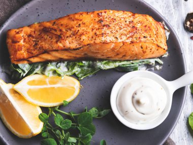 Limonlu, beyaz soslu ve ıspanaklı kızarmış somon filetosu.