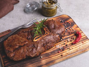 Kemikli ızgara biftek. Kesme tahtası, baharatlar, sos.