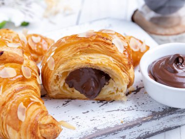 Lezzetli taze kruvasan, dilimlenmiş badem, çikolata dolgulu, yakın plan.