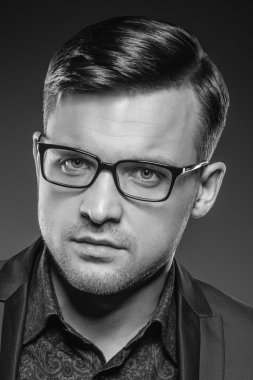 Yakışıklı genç adam bir takım elbise ve moda gözlük