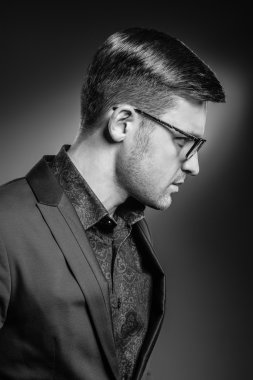 Yakışıklı genç adam bir takım elbise ve moda gözlük