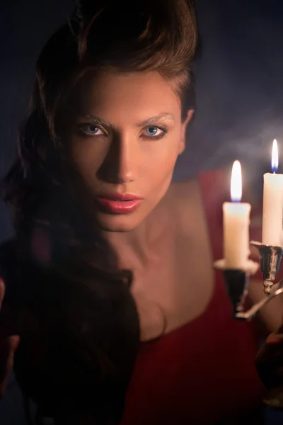 Mujer mirando velas rojas en la fabulosa noche — Foto de Stock