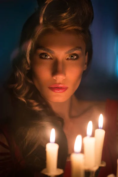 Frau blickt auf rote Kerzen in der fabelhaften Nacht — Stockfoto