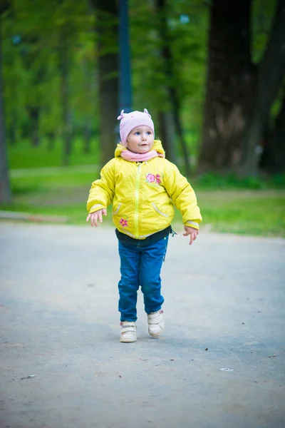 Funny baby girl in a yellow coat and pink hat — Stock Photo, Image