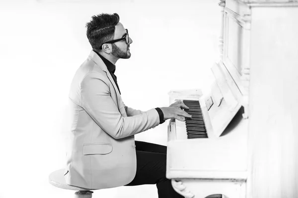 Cheerful young man in stylish suit is playing piano — Stock Photo, Image