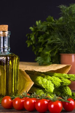 Ahşap bir masa üzerinde taze, yeşil kuşkonmaz