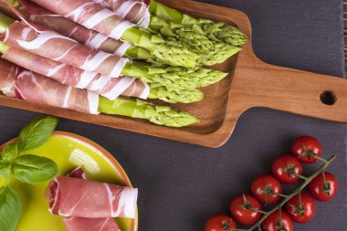 Ahşap bir masa üzerinde taze, yeşil kuşkonmaz