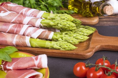 Ahşap bir masa üzerinde taze, yeşil kuşkonmaz