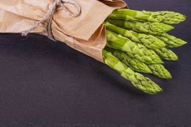 Ahşap bir masa üzerinde taze, yeşil kuşkonmaz