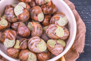 Ahşap arka plan üzerinde bir tabakta escargots de Bourgogne