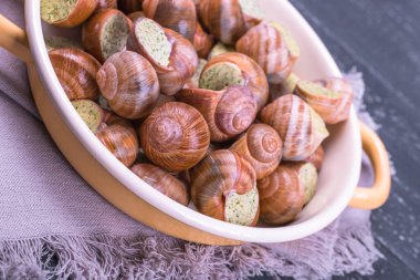 Ahşap arka plan üzerinde bir tabakta escargots de Bourgogne