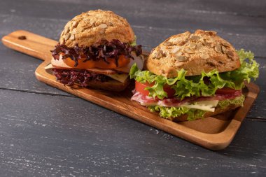 Salamlı sandviç ve ahşap arka planda salata.