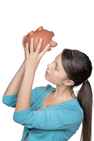 Mulher olhando para o banco porquinho para ver se ela tem algum dinheiro à esquerda — Fotografia de Stock
