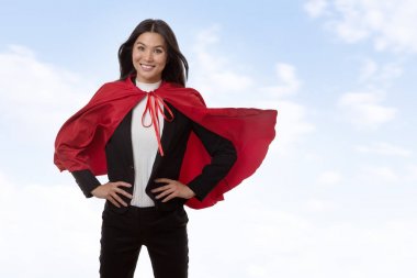 business woman wearing a super hero cape shot in the studio clipart
